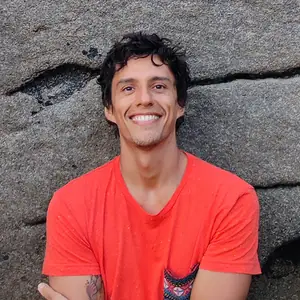 Lucas Narambuena, psicoterapeuta de Sanar La Trama, sonriendo con camiseta naranja